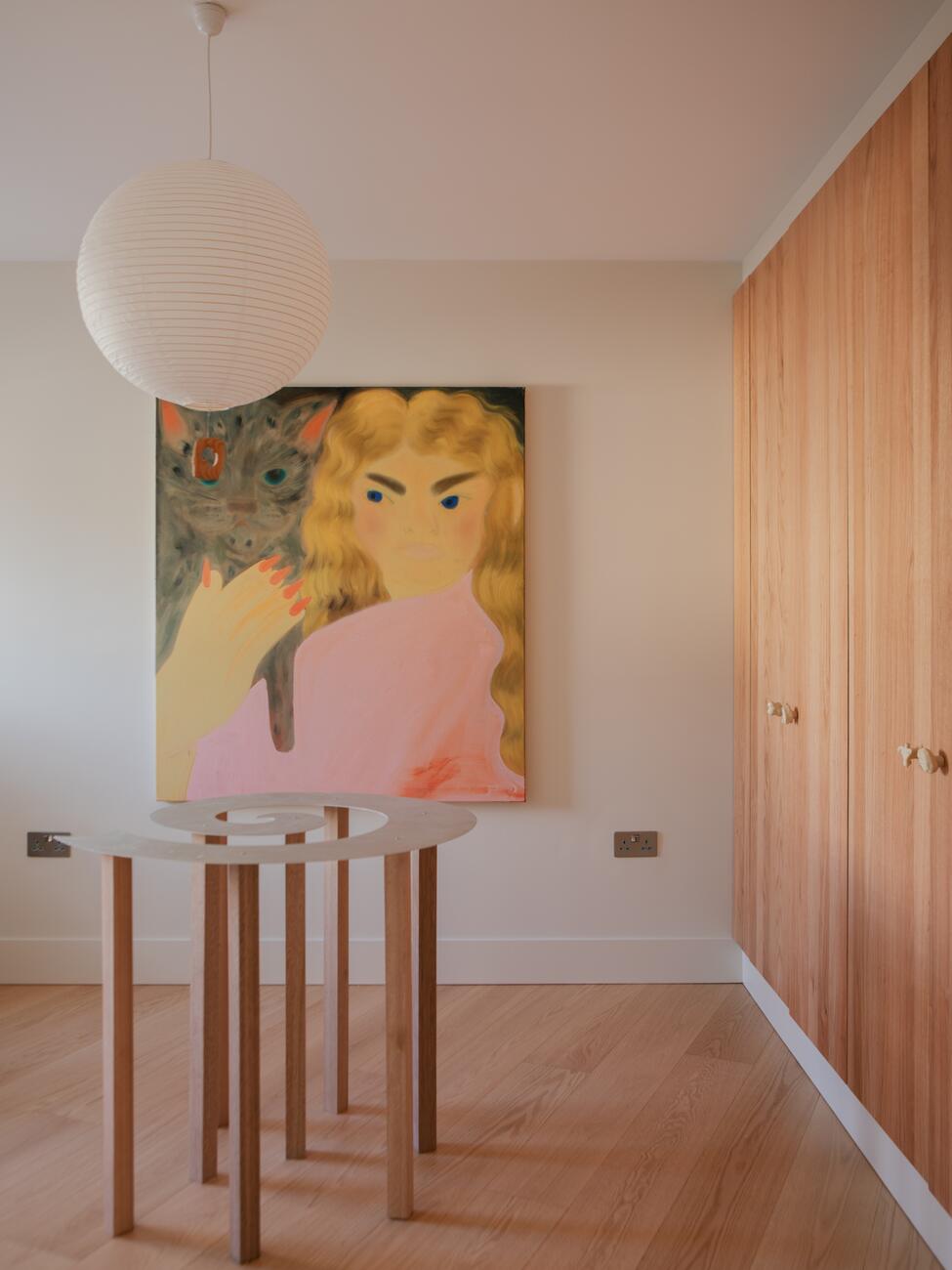 Paper lantern above a painting and a slender timber table